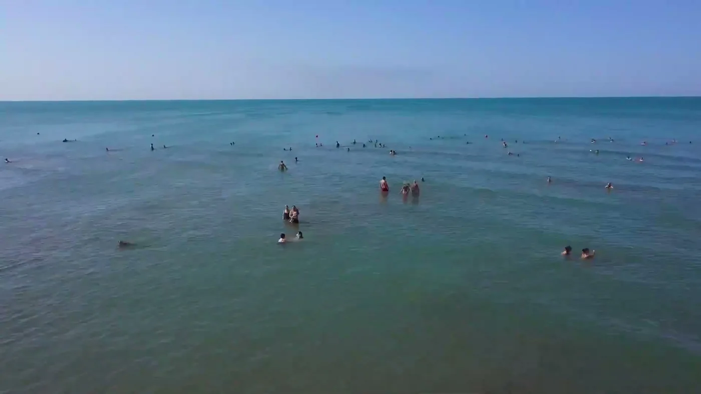 Море у берега Sea Breeze с дрона: купающиеся на спокойной воде, лето 2022